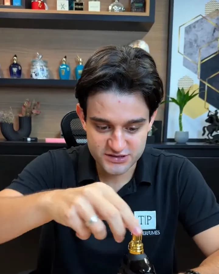 Gabriel remove a tampinha do frasco original na bancada