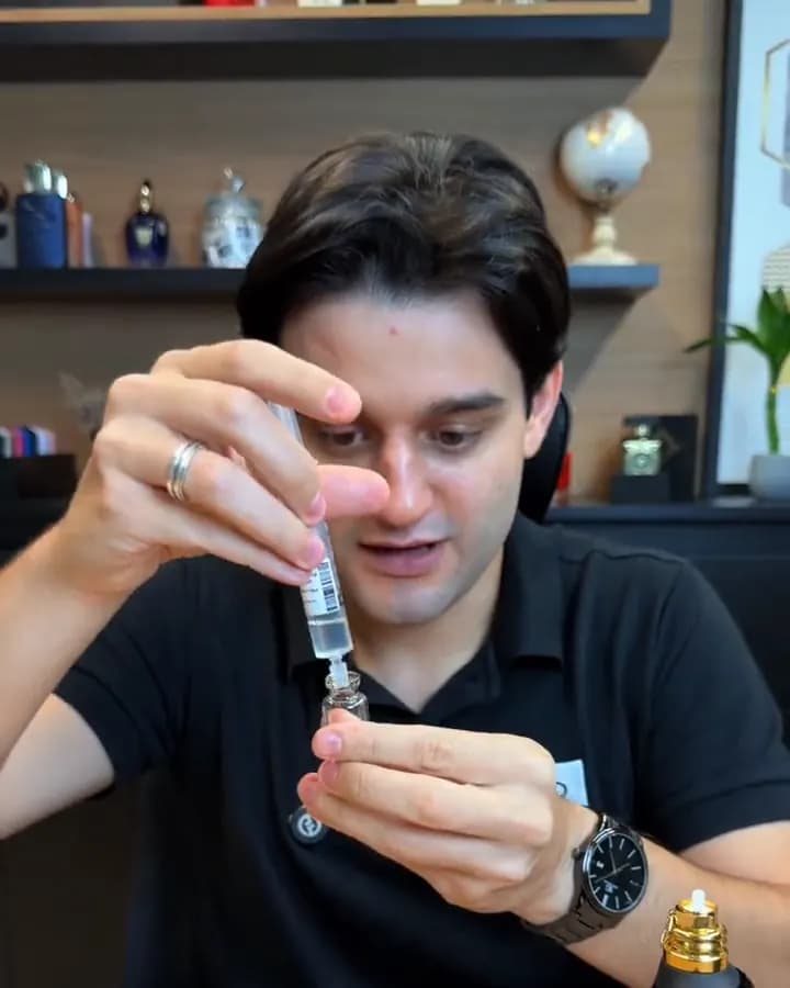 Gabriel transfere o perfume da seringa para o frasco de vidro do decant